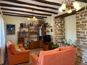 sala de estar con 2 sillas de color naranja y TV en Casa Moli, 