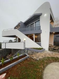 a white house with a staircase in front of it at Castra villas in Vandiperiyār