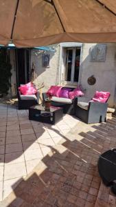 德拉吉尼昂的住宿－Le MAS DU SUD，天井配有沙发和带粉红色枕头的桌子。