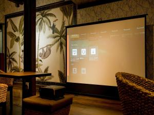 a projection screen in a room with a table and chairs at Yuraku Izu-Oshima - Vacation STAY 44742v in Oshima