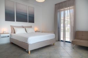 a bedroom with a bed and a couch and a window at Villa Rodanthi Sivota in Syvota