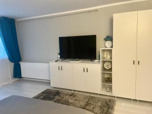 Ein Wohnzimmer mit einem Flachbildfernseher auf einem weißen Schrank. in der Unterkunft Elina studio in Drobeta-Turnu Severin