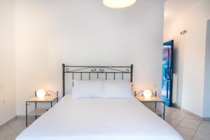 a bedroom with a large white bed with two lamps at Villa Rodanthi Sivota in Syvota