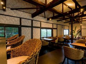 un restaurante con sillas de mimbre, mesas y ventanas en Yuraku Izu-Oshima - Vacation STAY 44742v, en Oshima