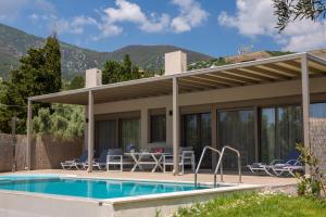 a villa with a swimming pool and a house at Averto Villas with private pool in Nydri