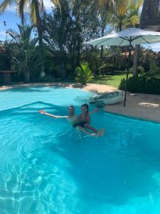 twee mensen zitten in een zwembad bij Casa Swell Coronado in Playa Coronado