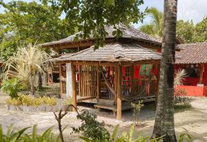 a small house with a hammock in front of it at Bangalôs da Aldeia Caraiva in Caraíva