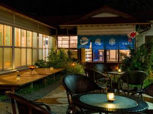 uma área de estar ao ar livre com mesas e cadeiras e uma mesa e cadeiras em Yuraku Izu-Oshima - Vacation STAY 44711v em Oshima