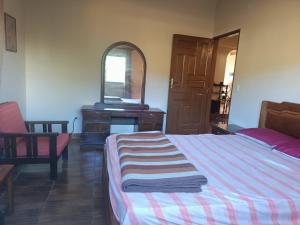 1 dormitorio con cama, tocador y espejo en Boom Tribe, en Samaipata