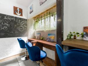 une salle de classe avec des chaises bleues et un tableau noir sur le mur dans l'établissement Yuraku Izu-Oshima - Vacation STAY 44711v, à Oshima