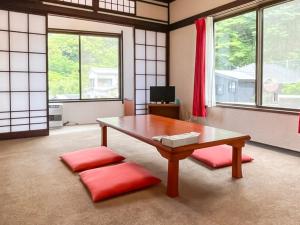 a living room with a table and red cushions at Yuraku Izu-Oshima - Vacation STAY 44711v in Oshima