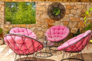 three pink chairs and a table in a patio at Mai's Cottage in Stari Grad