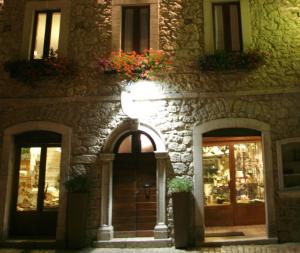 a stone building with two doors and flowers on it at Affittacamere Prato Rosso in Pescasseroli