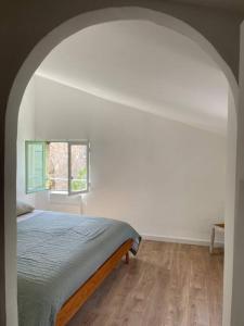 een slaapkamer met een bed en een raam bij House in idyllic village between vineyards and sea in Saint-Pons-de-Mauchiens