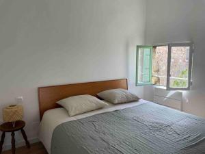 een slaapkamer met een groot bed en een raam bij House in idyllic village between vineyards and sea in Saint-Pons-de-Mauchiens