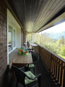 eine Veranda mit einem Tisch, Stühlen und einem Fenster in der Unterkunft Ferienhaus Nussbaumer in Sibratsgfäll