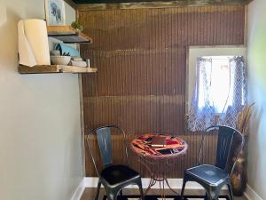 a room with two chairs and a table and a window at Cabin 9 at Horse Creek Resort in Rapid City