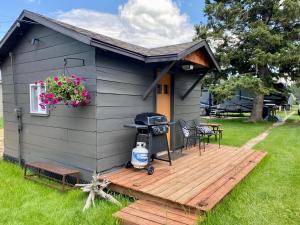 a small house with a deck and a grill at Cabin 9 at Horse Creek Resort in Rapid City