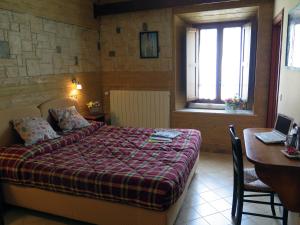 a bedroom with a bed and a table with a laptop at Affittacamere Prato Rosso in Pescasseroli