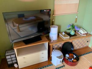 uma televisão sentada num suporte de madeira com uma televisão em Kofukan - Vacation STAY 64890v em Myoko
