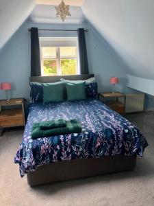 a bedroom with a bed with a blue comforter at The Annexe at Walnut Tree Cottage in Hope under Dinmore