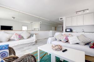 マルベーリャにあるPuerto Banus Harbour View Apartmentのリビングルーム(白いソファ2台、テーブル付)