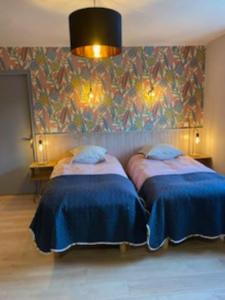 two beds in a room with a wall at La Plante, tendance et design in Ornans