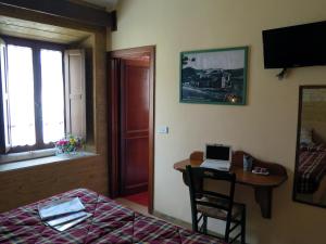 a bedroom with a bed and a desk with a laptop at Affittacamere Prato Rosso in Pescasseroli