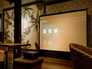 a projection screen in a room with a table and chairs at Yuraku Izu-Oshima - Vacation STAY 44735v in Oshima