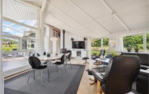 SpodsbjergにあるLovely Home In Rudkbing With Wifiのリビングルーム(テーブル、椅子付)