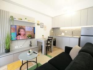 uma sala de estar com um sofá e uma televisão na parede em Comfy Studio at 'Mangalem21 Complex' Parking-WiFi-AC-View em Tirana