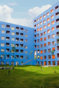 un edificio de apartamentos azul junto a un campo verde en Comfy Studio at 'Mangalem21 Complex' Parking-WiFi-AC-View en Tirana