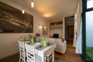 una cucina e un soggiorno con tavolo e sedie bianchi di Patio 15 - Pools, tennis and water sports a Iseo