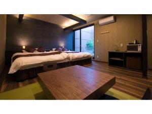 Oita Onsen Business Resort Sourin - Vacation STAY 73383v في أويتا: غرفة نوم بسرير كبير ونافذة كبيرة