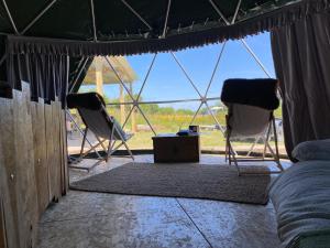 a tent with two chairs and a table in a room at Geodesic Dome Glamping in Llanidloes