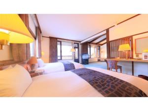 青森市にあるSukayu Onsen Hakkoda Hotel - Vacation STAY 66845vのベッド2台とデスクが備わるホテルルームです。