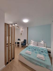 - une chambre avec un lit, un bureau et une table dans l'établissement HARMONY Suites (Savska ulica), à Sajmište