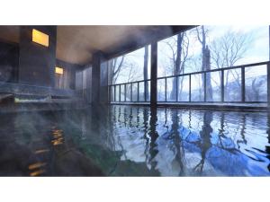 青森市にあるSukayu Onsen Hakkoda Hotel - Vacation STAY 66849vの窓のある建物内の水のプール