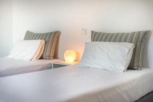 a bedroom with two beds with pillows and a lamp at Villa Rodanthi Sivota in Syvota