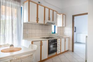 a kitchen with white cabinets and a stove top oven at Villa Rodanthi Sivota in Syvota