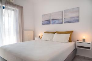 a white bedroom with a large bed and a window at Villa Rodanthi Sivota in Syvota