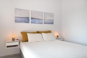 a bedroom with a bed with three paintings on the wall at Villa Rodanthi Sivota in Syvota