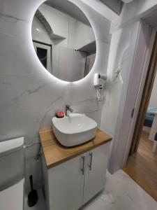 a bathroom with a sink and a mirror at HARMONY Suites (Savska ulica) in Sajmište