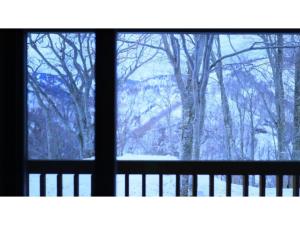 青森市にあるSukayu Onsen Hakkoda Hotel - Vacation STAY 66848vの雪に覆われた森の景色を望む窓