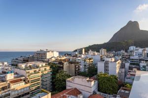 a city with buildings and the ocean in the background at Belo no Leblon - Vista para Morro 2 irmãos - GUC6 ZN1 in Rio de Janeiro