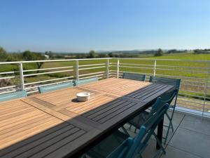 einen Holztisch mit einer Tasse und zwei Stühlen auf einer Terrasse in der Unterkunft La Baie des 2 Caps in Tardinghen