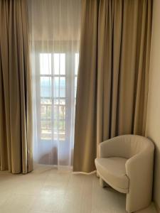 a white chair in a room with a window at Viva Properties in Ouranoupoli