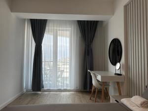 een slaapkamer met een bed, een bureau en een raam bij SeaSide Infinity Resort in Mamaia Nord – Năvodari