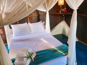 a bedroom with a bed with a canopy at Bangalôs da Aldeia Caraíva in Caraíva