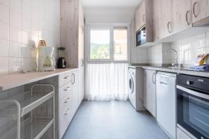 une cuisine avec des placards blancs et une fenêtre dans l'établissement Sukarrieta Home, à Pedernales